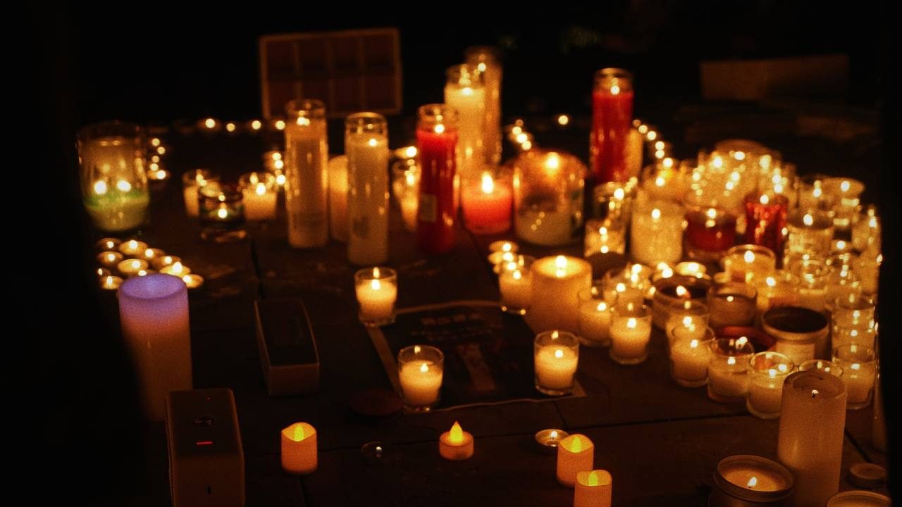 People holding candles at a nighttime vigil