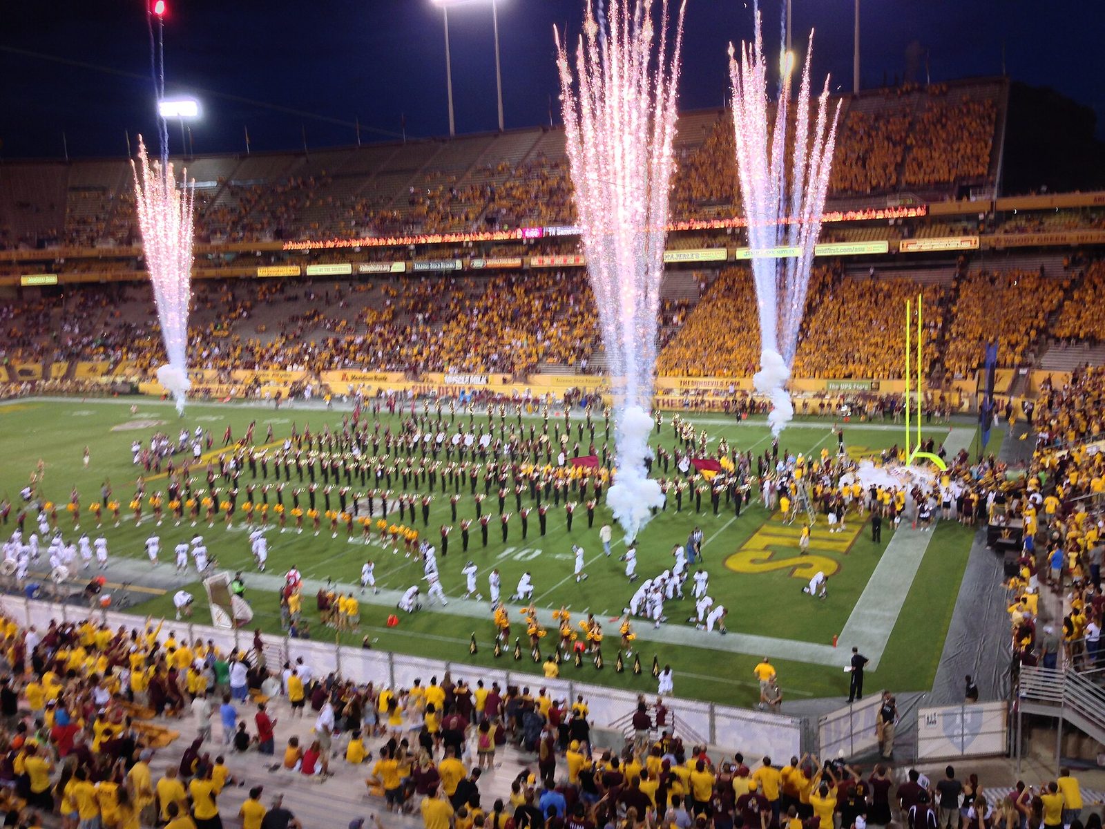 A college football team running onto the field